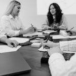 A group of colleagues engaged in a brainstorming session around a table, planning strategies.